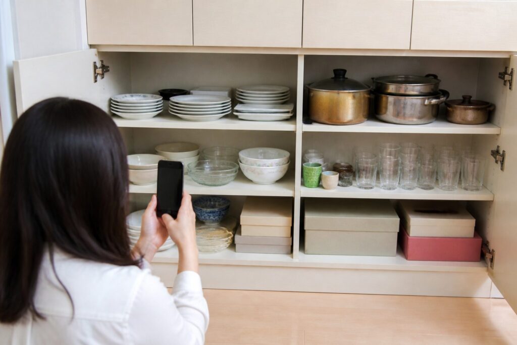 川崎市高津区で分別不要の不用品回収を相談するため食器棚の中を確認するイメージ
